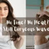 A horizontal photo collage split into two equal panels, as referenced in the file No Time No Heat Still Gorgeous Waves.webp. The left panel shows a young woman with long, dark brown wavy hair looking forward while gently scrunching her hair with her hands, wearing a plain white t-shirt against a clean white background. The right panel displays a profile view of a young woman with a white towel wrapped around her torso, gathering her damp blonde hair in a bathroom with white tiles and a turquoise wall accent. Overlaid across the center of both panels is a translucent grey rectangular banner featuring stylized white text that reads, "No Time? No Heat? Still Gorgeous Waves".