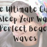 A horizontal graphic design featuring a close-up portrait of a young woman smiling, as referenced in the file The Ultimate Guide to Sleep Your Way to Perfect Beach Waves (1).webp. She has dark hair and is looking slightly to the left, wearing a white headscarf adorned with vibrant floral patterns in pink, blue, and green. The entire image is softened by a faint, semi-transparent white overlay, which displays prominent dark grey or black text in a casual, handwritten script font. The text reads: "The Ultimate Guide to Sleep Your Way to Perfect Beach Waves". The background behind her features a subtly patterned textile fabric.