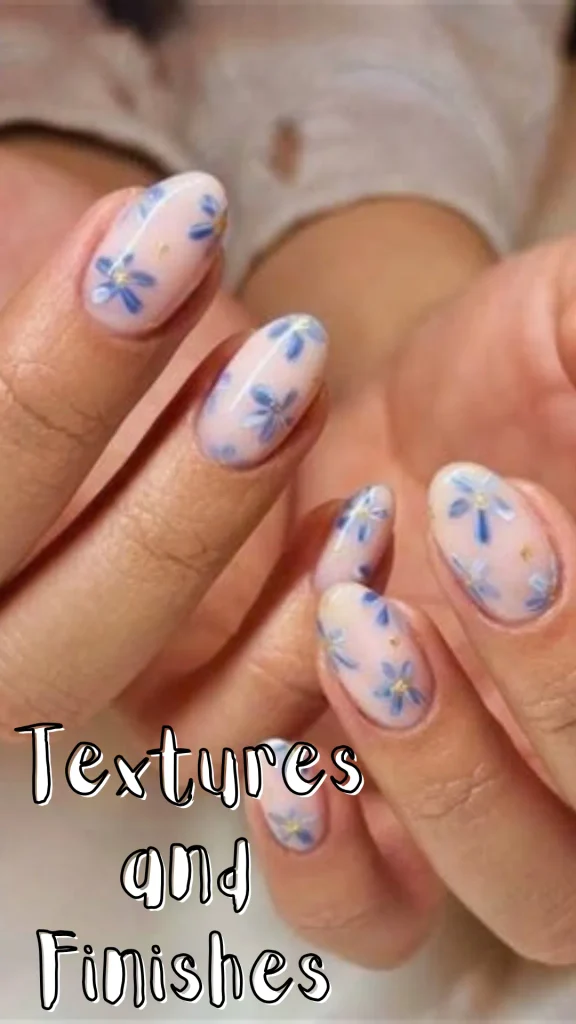 Close-up of almond-shaped nails featuring a translucent nude base decorated with delicate blue flower art and gold accents, with overlay text reading "Textures and Finishes".