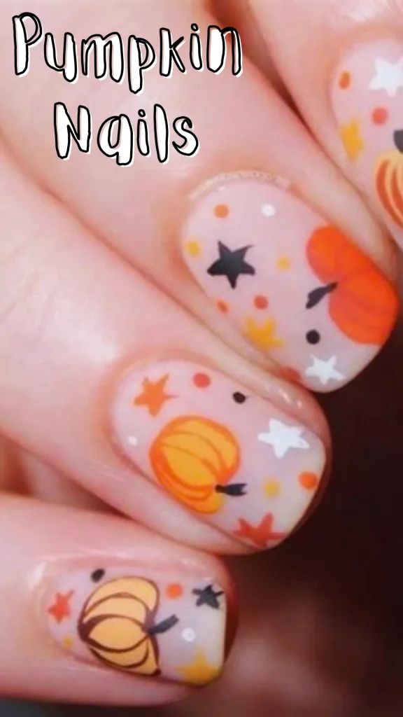 Close-up of short round nails painted light pink with festive autumn art featuring orange pumpkins, stars, and tiny dots, with overlay text reading "Pumpkin Nails".